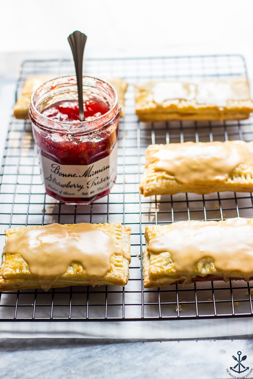 Homemade Peanut Butter and Jelly Pop-Tarts on a wire rack with a jar of preserves