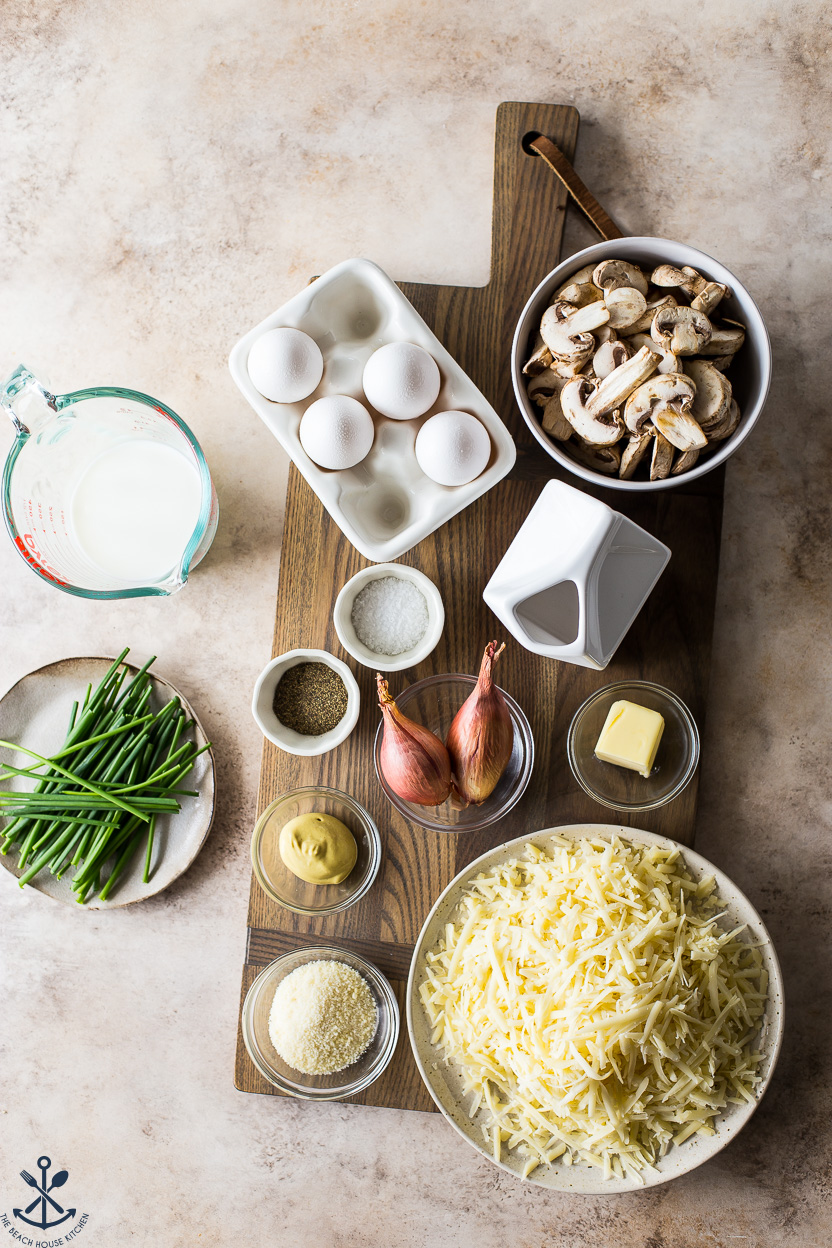 Overhead photo of ingredients for a mushroom quiche on a wooden board