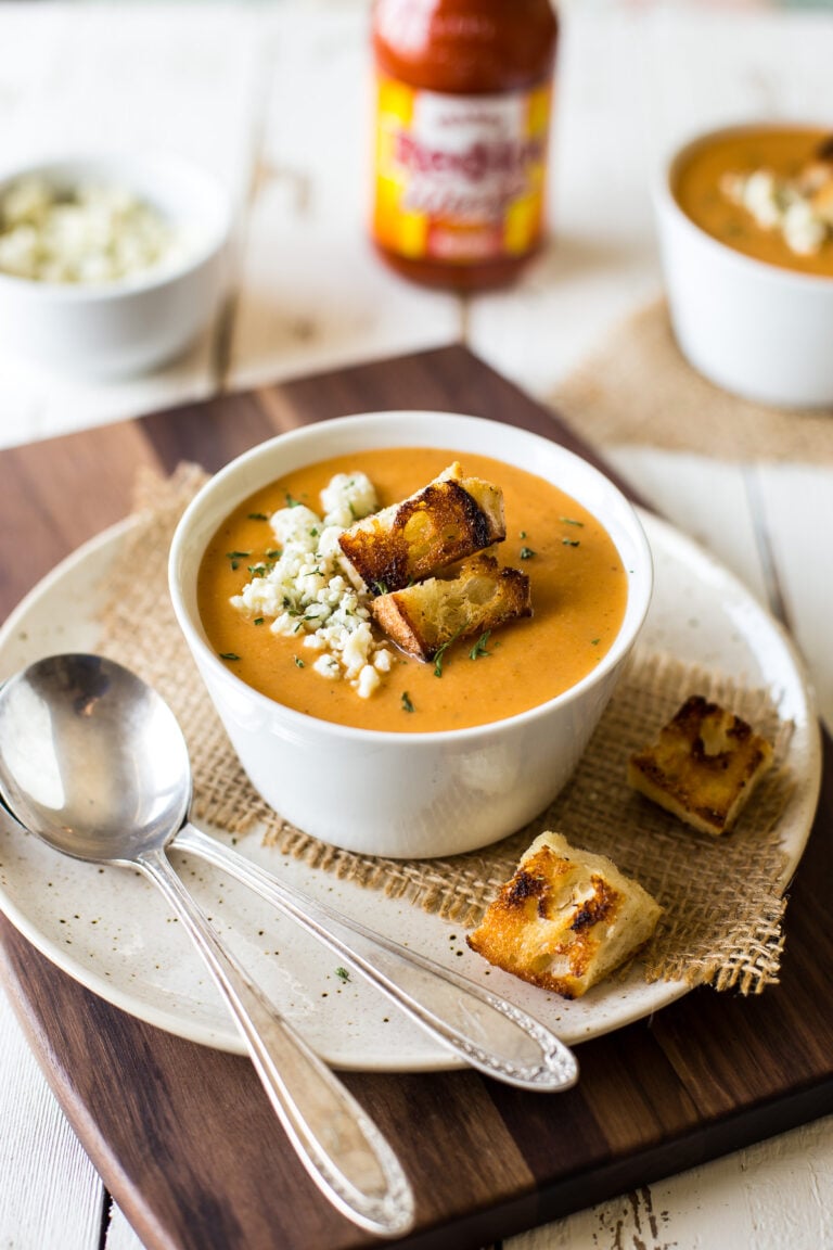 A bowl of buffalo cauliflower soup on a plate