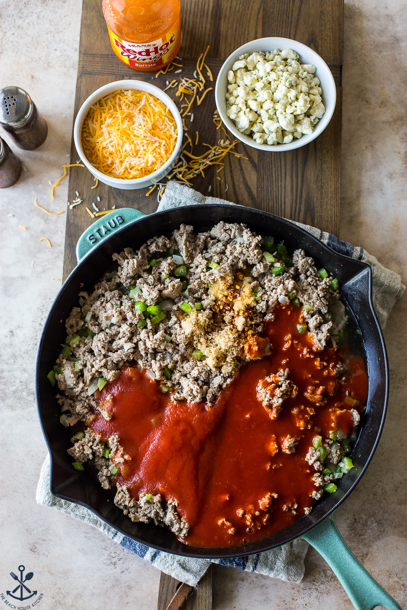 Overhead photo of a skillet filled with cooked turkey meat, tomato sauce and veggies