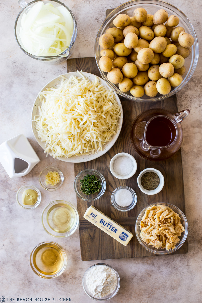 Overhead photo of ingredients for cheesy potatoes on a wooden board