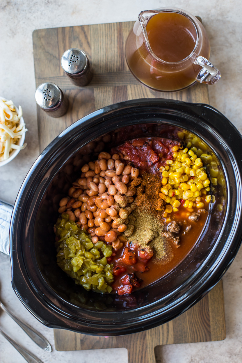 Overhead photo of a slow cooker filled with beef enchilada soup ingredients