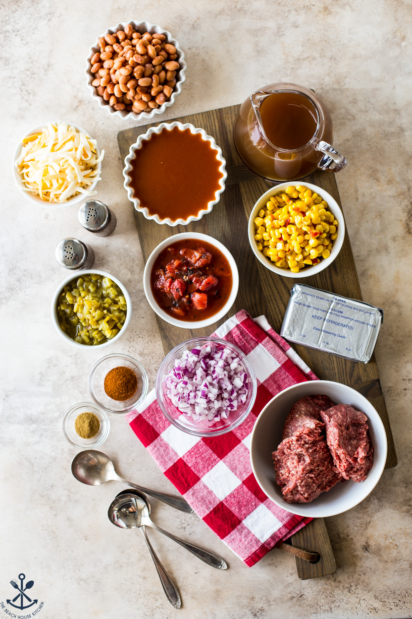 Overhead photo of slow cooker beef enchilada soup ingredients on a wooden board
