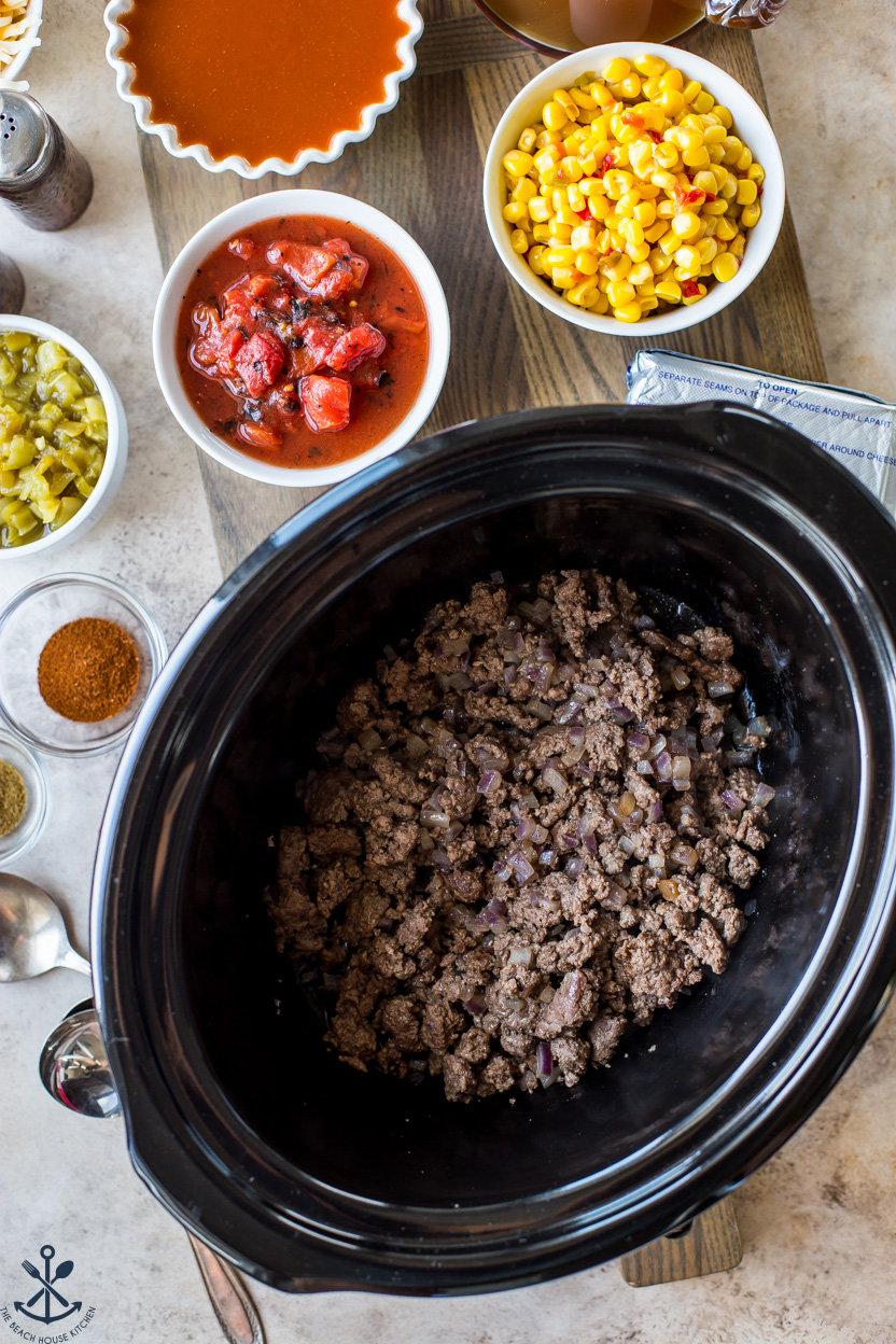 Overhead photo a a slow cooker filled with cooked ground beef and onions