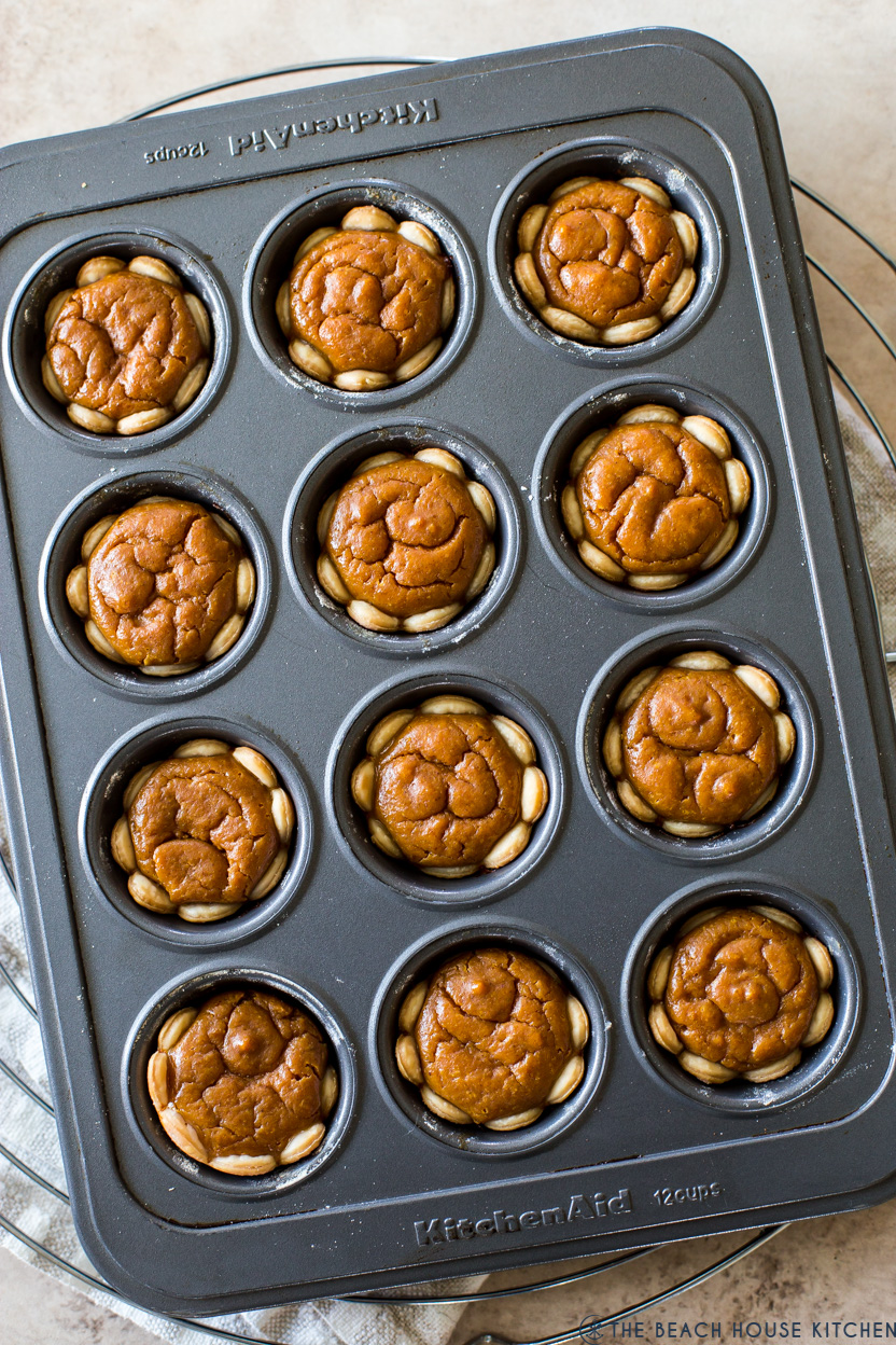 Up close overhead photo of mini pumpkin pies in a muffin tin