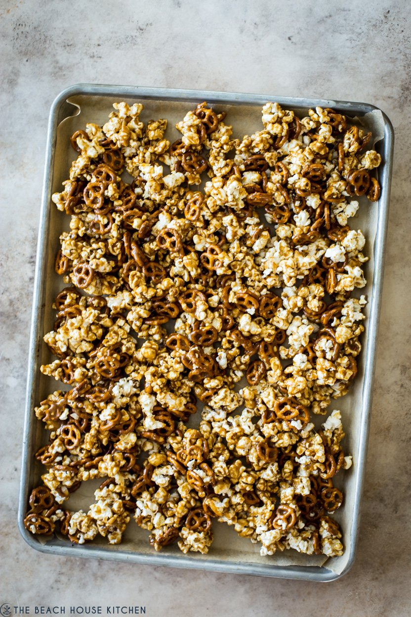 Overhead photo of pre-baked caramel popcorn on a baking sheet