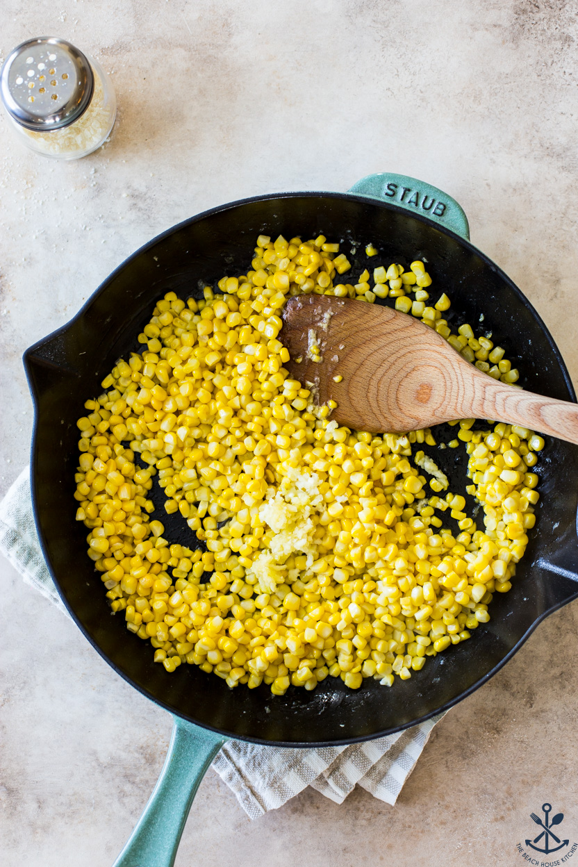 Overhead photo of a skillet of corn and minced garlic