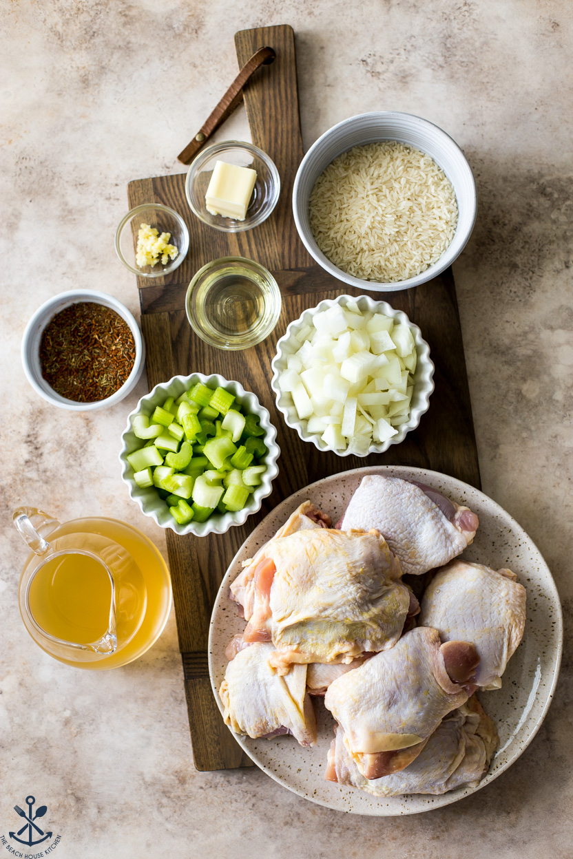 Overhead photo of ingredients for a chicken and rice dish on a wooden board