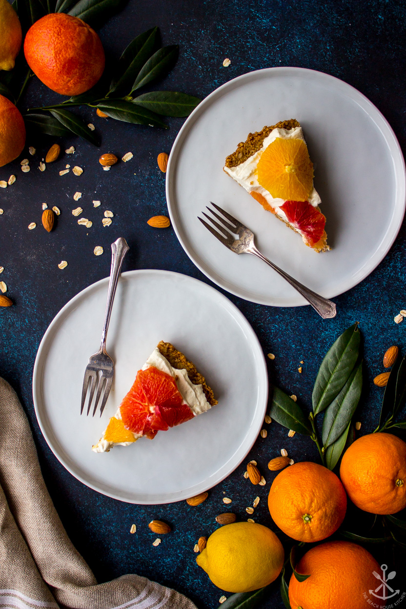 Overhead photo of slices of a citrus tart on white plates