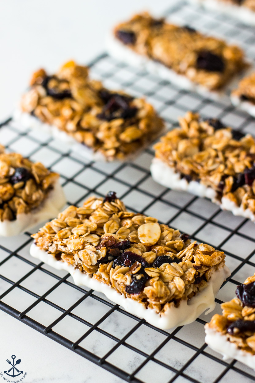 Up close photo of Chewy White Chocolate Dipped Blueberry Granola Bars on a wire cooling rack