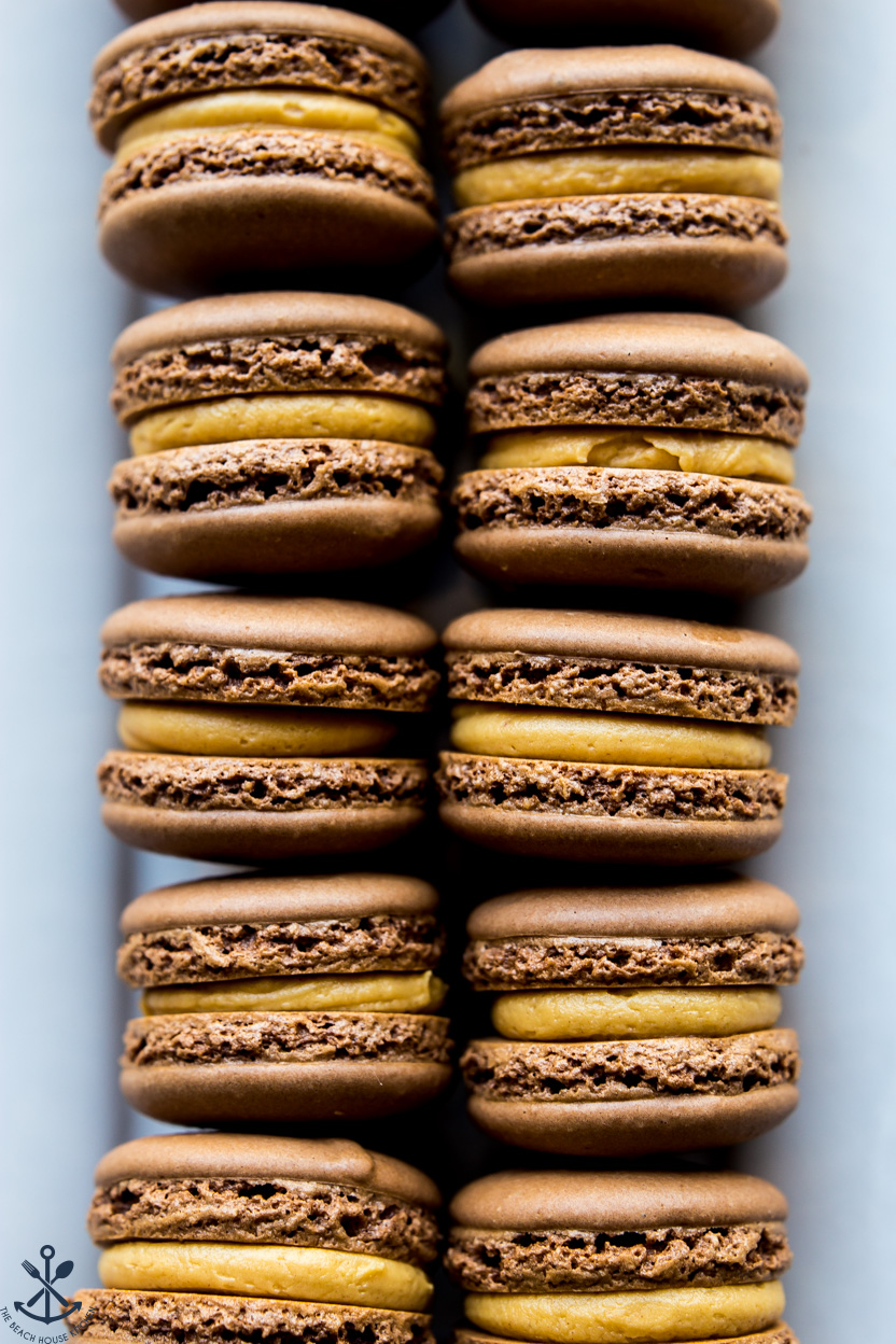 Up close overhead photo of a tray of chocolate peanut butter macarons
