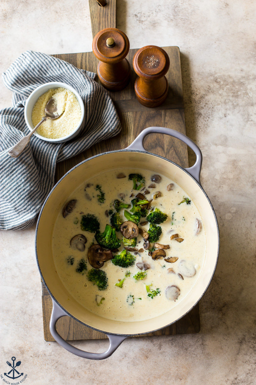 Overhead photo of a pot of creamy sauce with broccoli and mushrooms