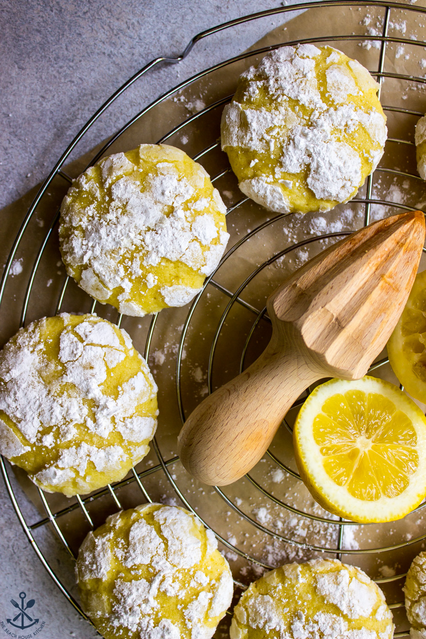Up close photo of lemon crinkle cookies on a silver round wire rack