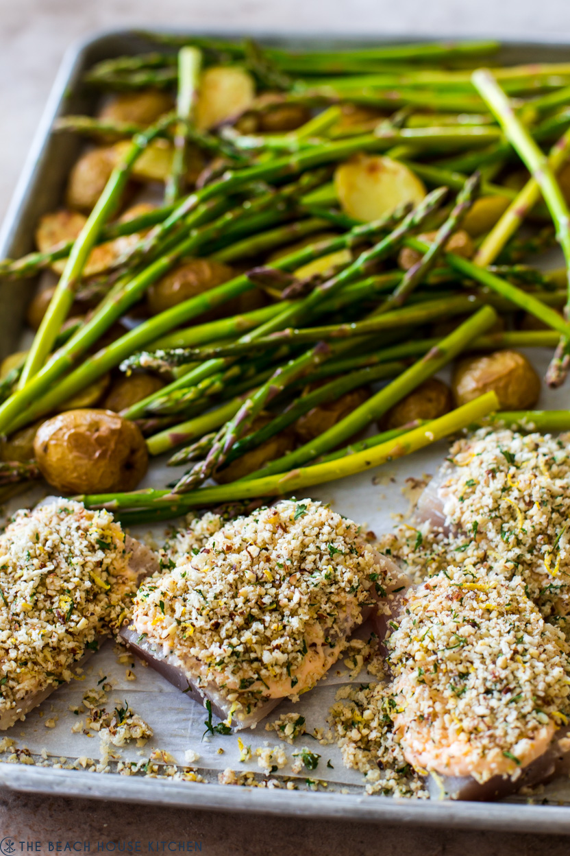 A tray of pre-cooked mahi mahi fillets with asparagus and potatoes