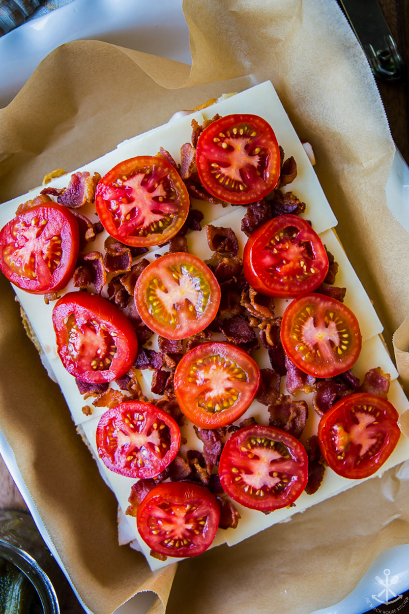 Overhead photo of tomato and bacon topped pre-baked slider sandwiches