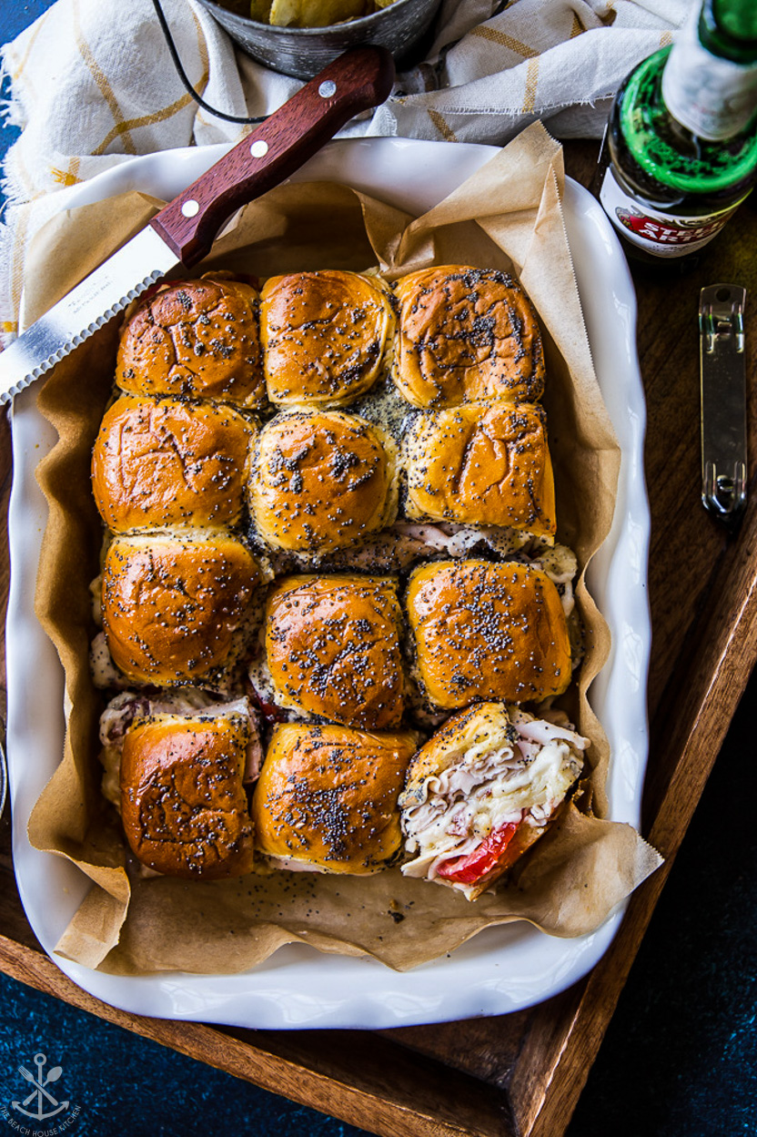 Overhead photo of a baking dish of sliders with turkey and tomatoes