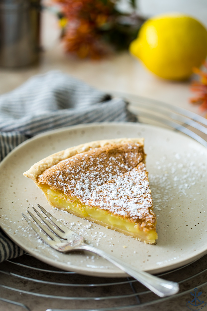 A slice of lemon pie on a plate with a fork