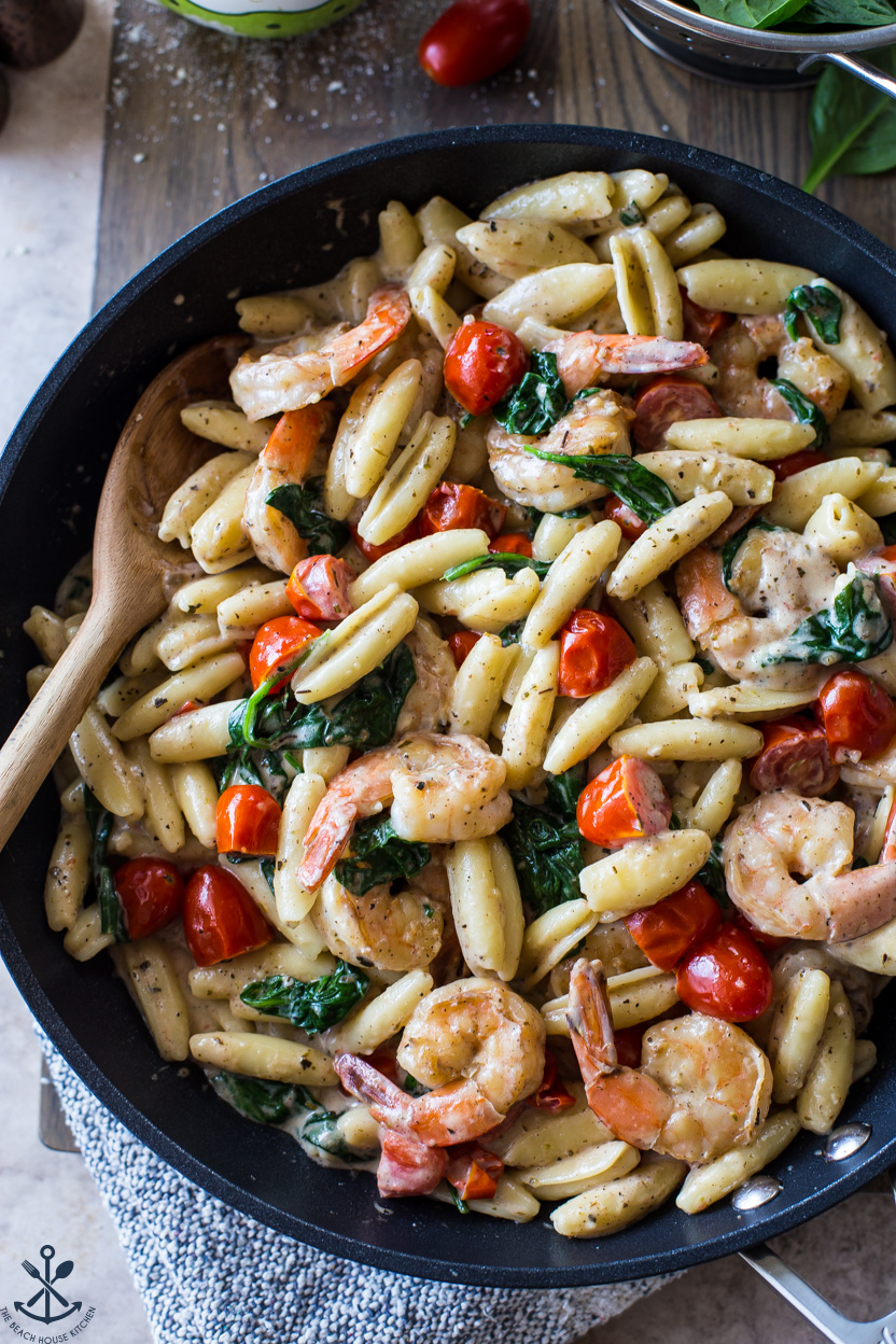 Up close overhead photo of skillet filled with Shrimp Pasta with Garlic Cream Sauce Tomatoes and Spinach