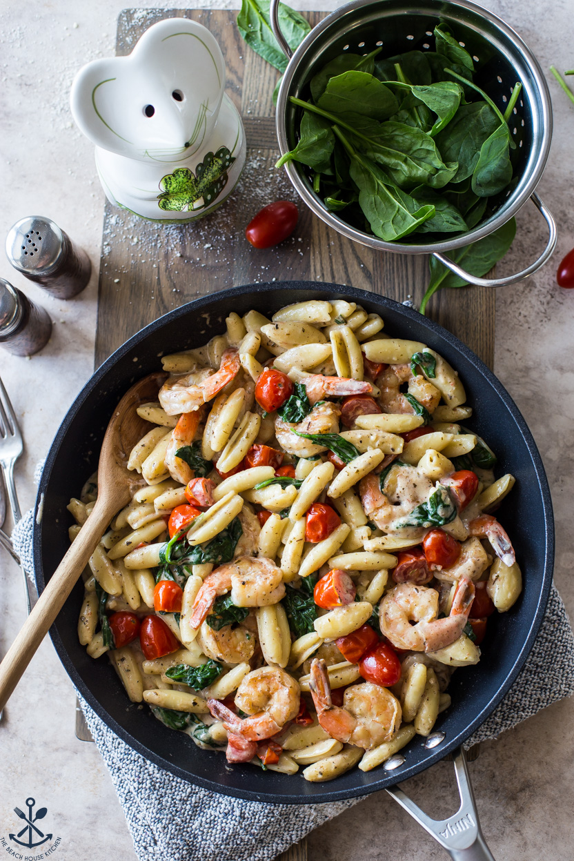 Overhead photo of a skillet of Shrimp Pasta with Garlic Cream Sauce Tomatoes and Spinach