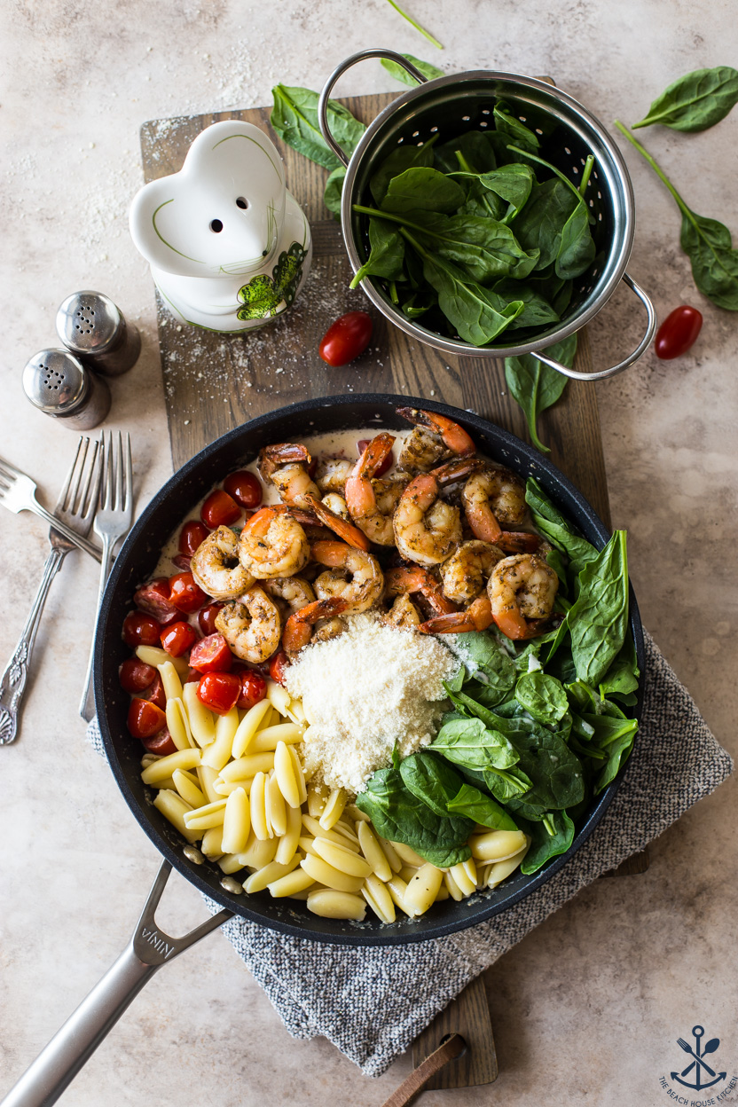 Overhead photo of a skillet of pasta and shrimp and veggies before it's all mixed together