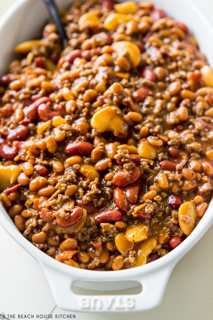 A baked bean casserole in a white oval baking dish