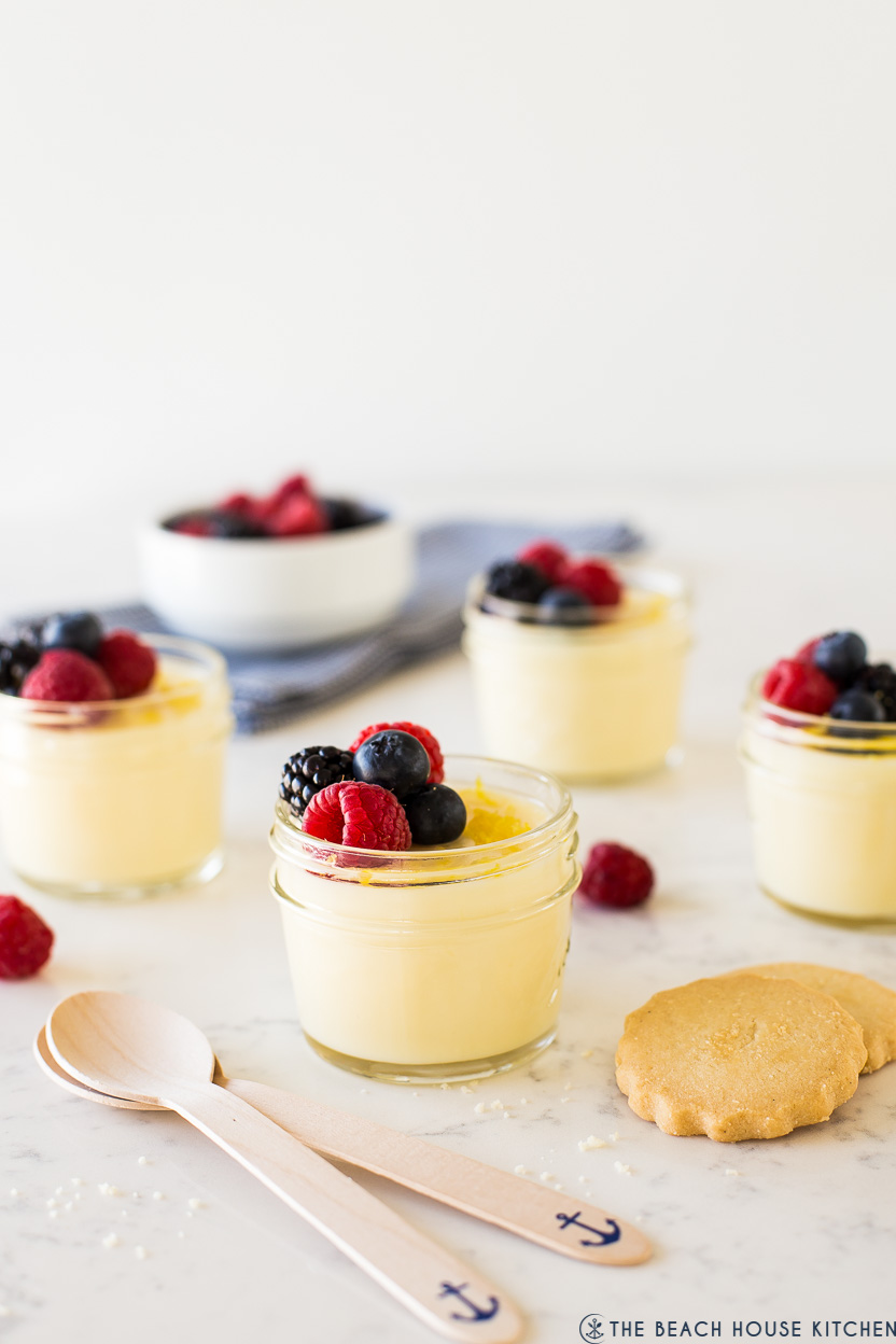 Lemon posset in glass jars topped with berries