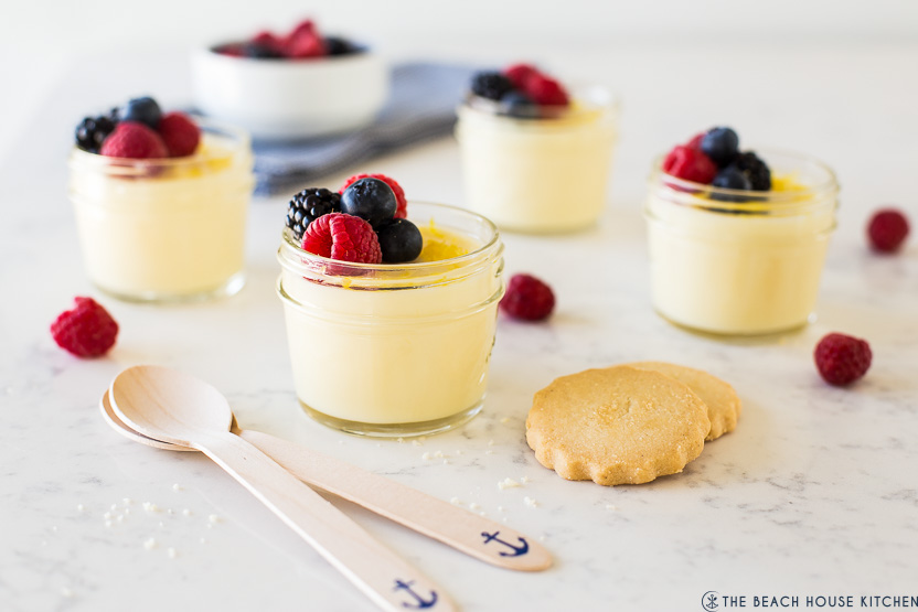 Jars filled with a lemon pudding topped with berries