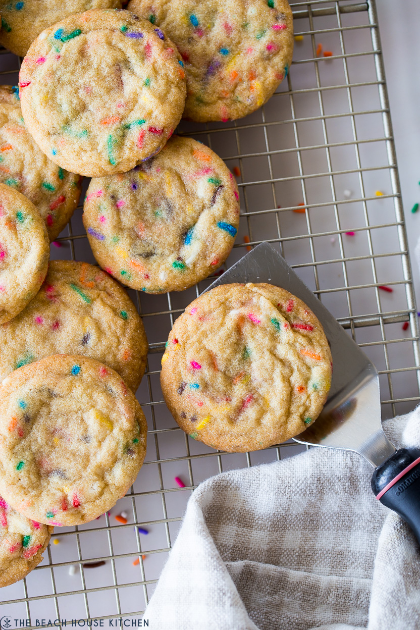 Up close overhead photo of chewy brown sugar funfetti cookies on a wire rack