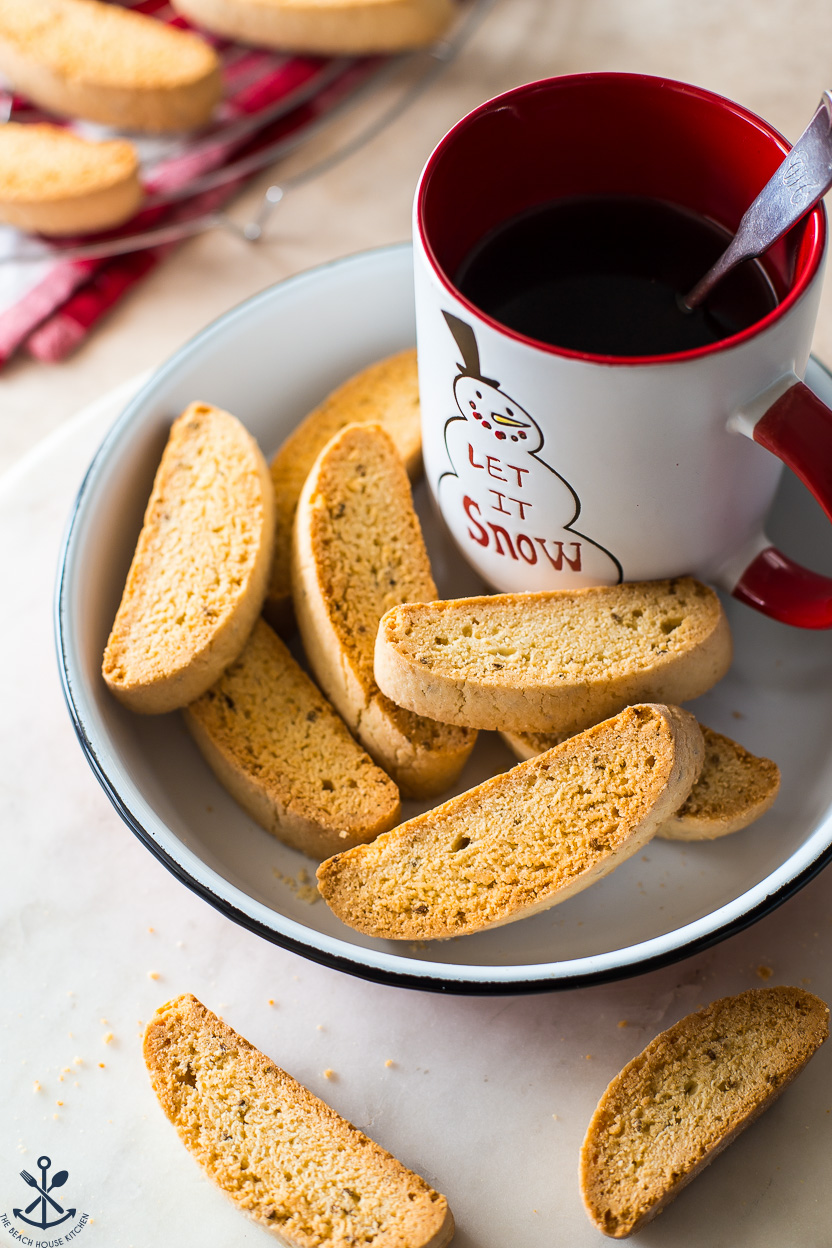 Some Anise Biscotti and a mug of hot cocoa in a white enamel dish