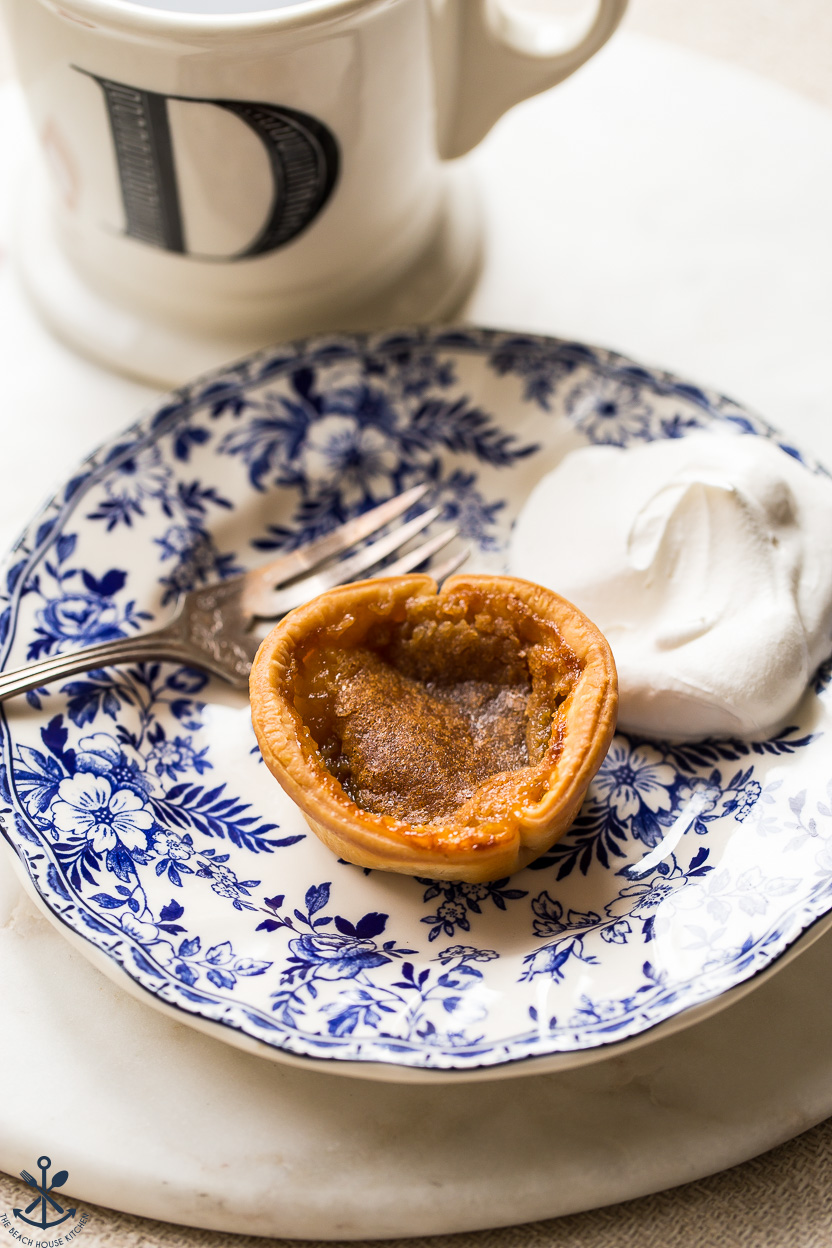 A Canadian butter tart on a blue a white plate with a fork
