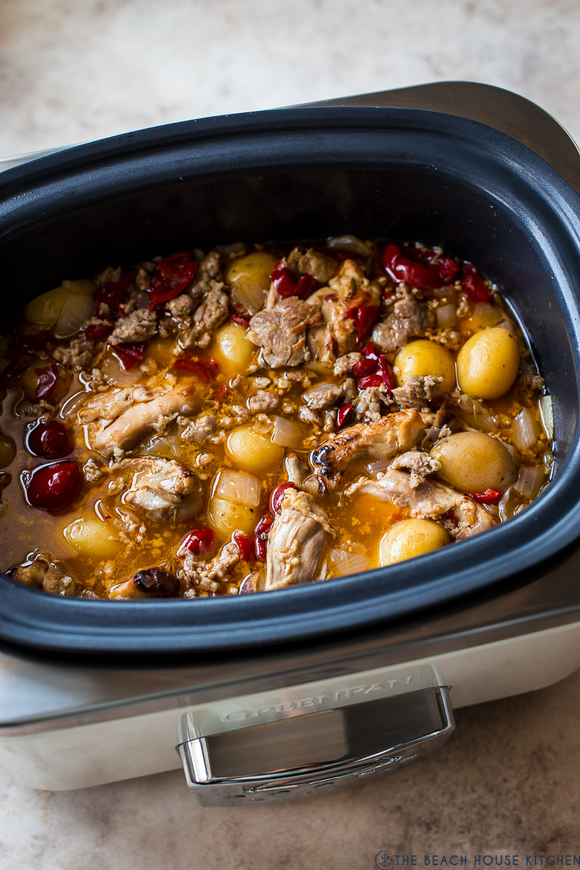 A slow cooker filled with chicken scarpariello