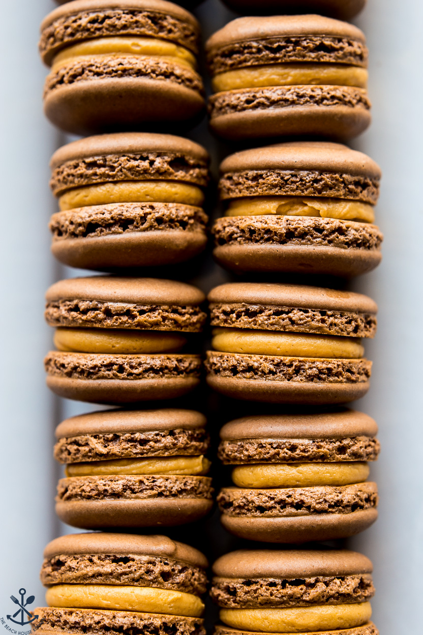 Up close overhead photo of a plate of chocolate peanut butter macarons