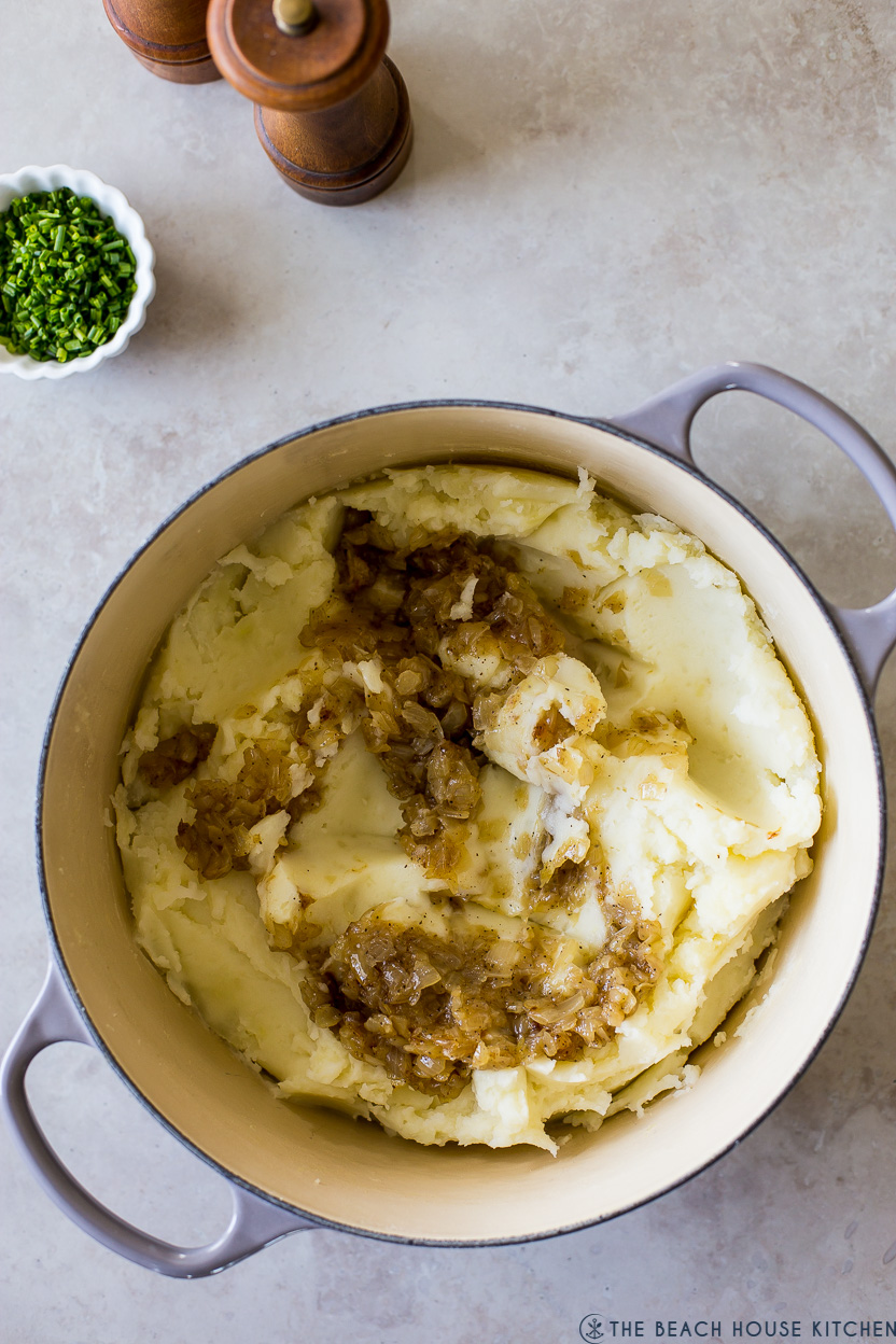 Overhead photo of a pot of mashed potatoes with caramelized onions
