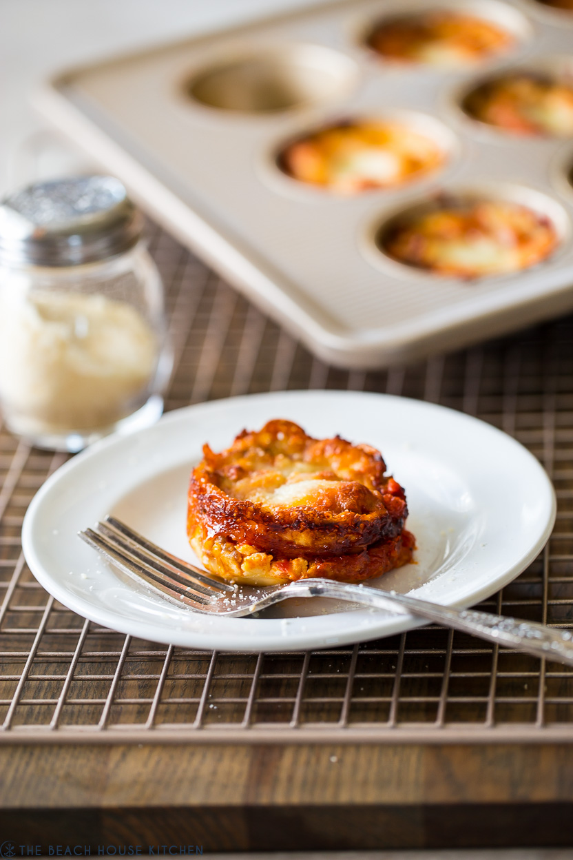 A lasagna cup on a white plate with a fork