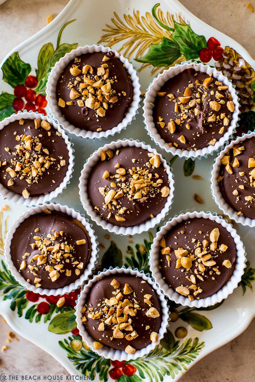 Overhead photo of a plate of homemade snickers cups topped with nuts