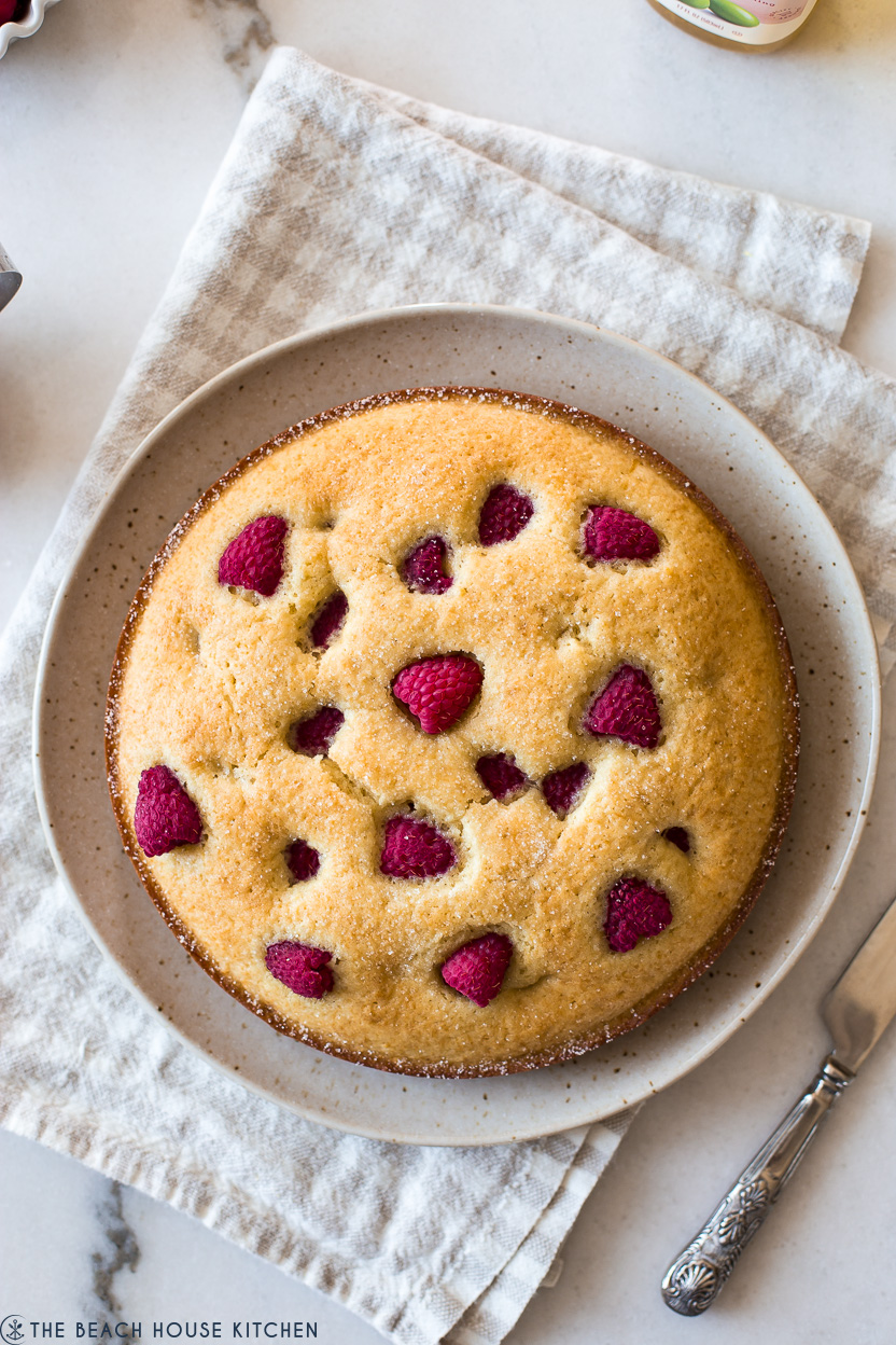 Overhead photo of a round cake topped with raspberries