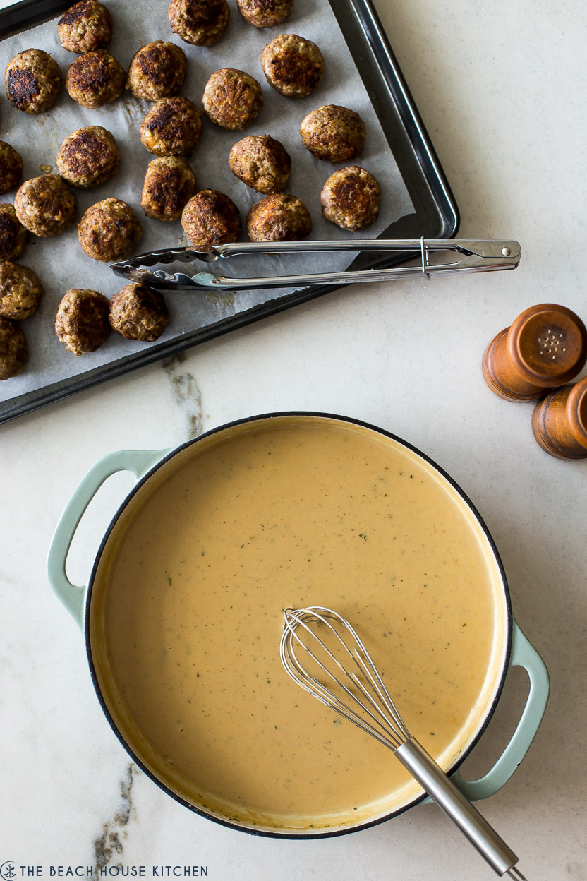 Overhead photo of Swedish Meatball gravy in a skillet and a tray of meatballs