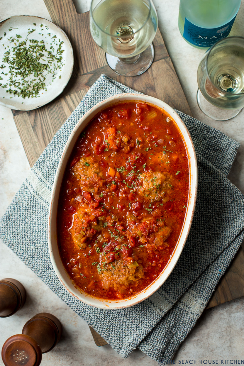Overhead photo of a baking dish of chicken with a rich tomato sauce