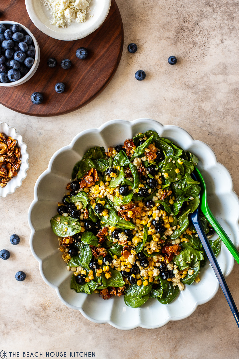Overhead photo of a white scalloped platter filled with a blueberry corn salad