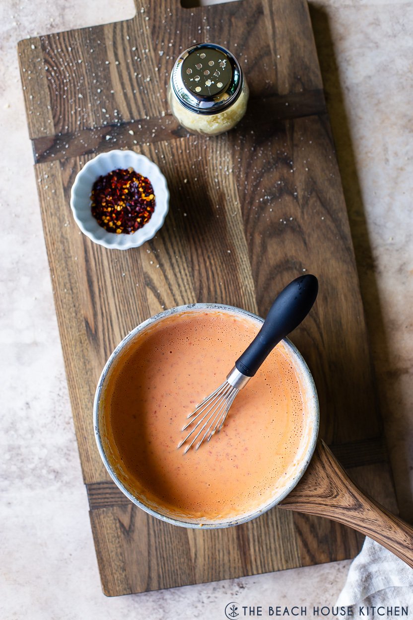 Overhead photo of a saucepan of roasted red pepper alfredo sauce