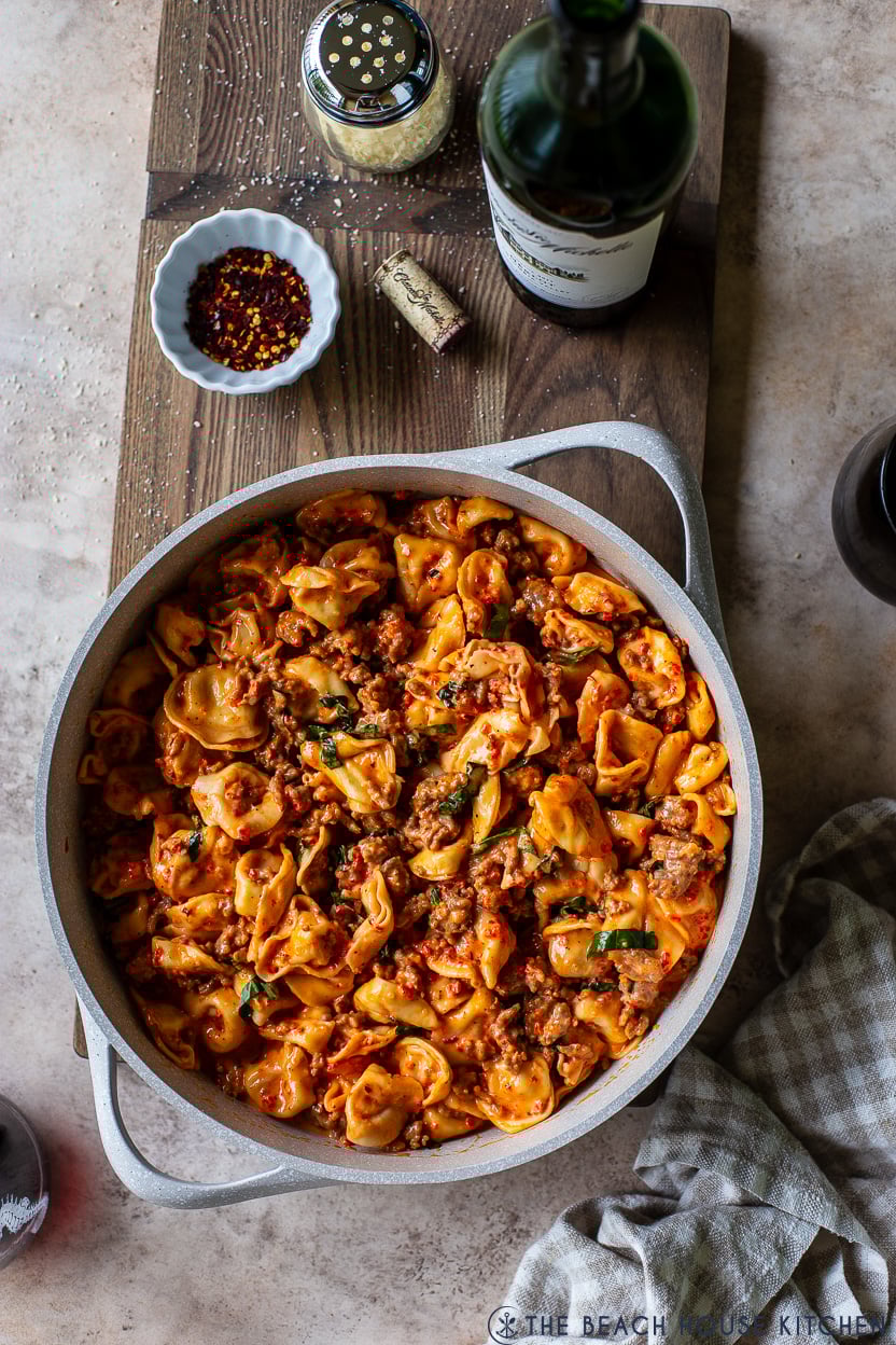 Overhead photo of a skillet of Roasted Red Pepper Tortellini Alfredo with Sausage