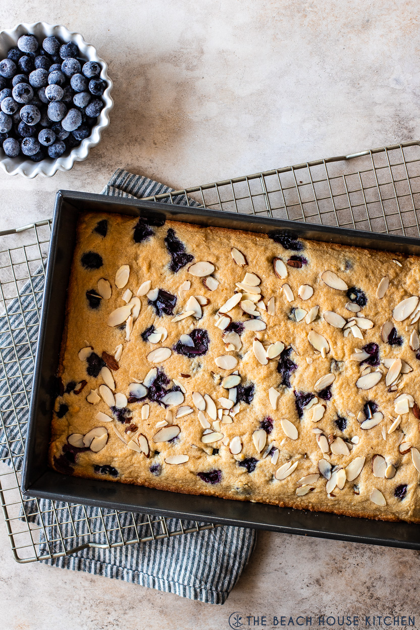 Overhead photo of a tray of blueberry lemon Blondies and a small bowl of blueberries