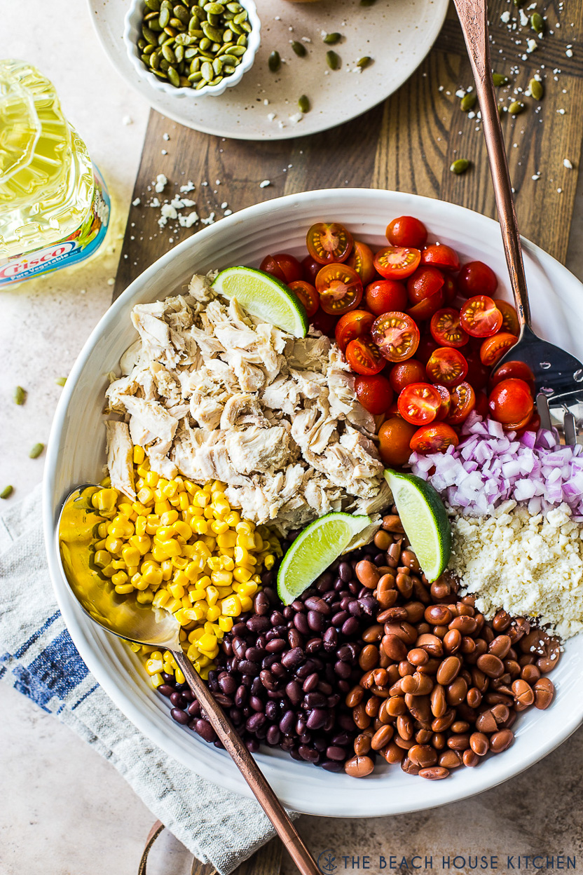 Overhead photo of a pre-mixed salad with chicken, beans, corn, tomatoes, onions and cheese