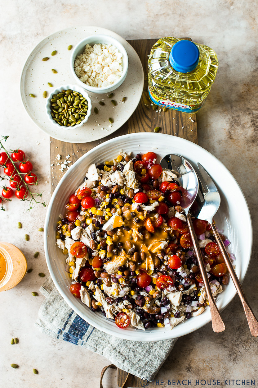 Overhead photo of a platter of a southwest chicken salad topped with a dressing