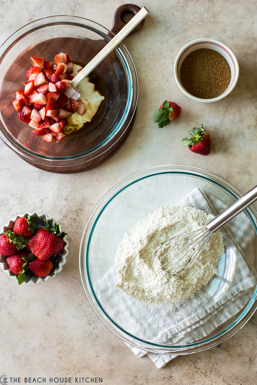 Overhead photo of a bowl of flour and a bowl of chopped strawberries