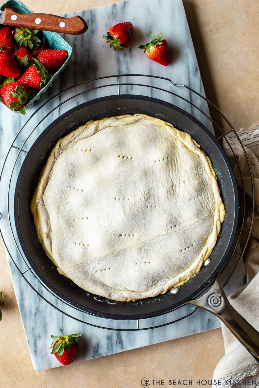 Overhead photo of a skillet of a pre-baked tarte tatin
