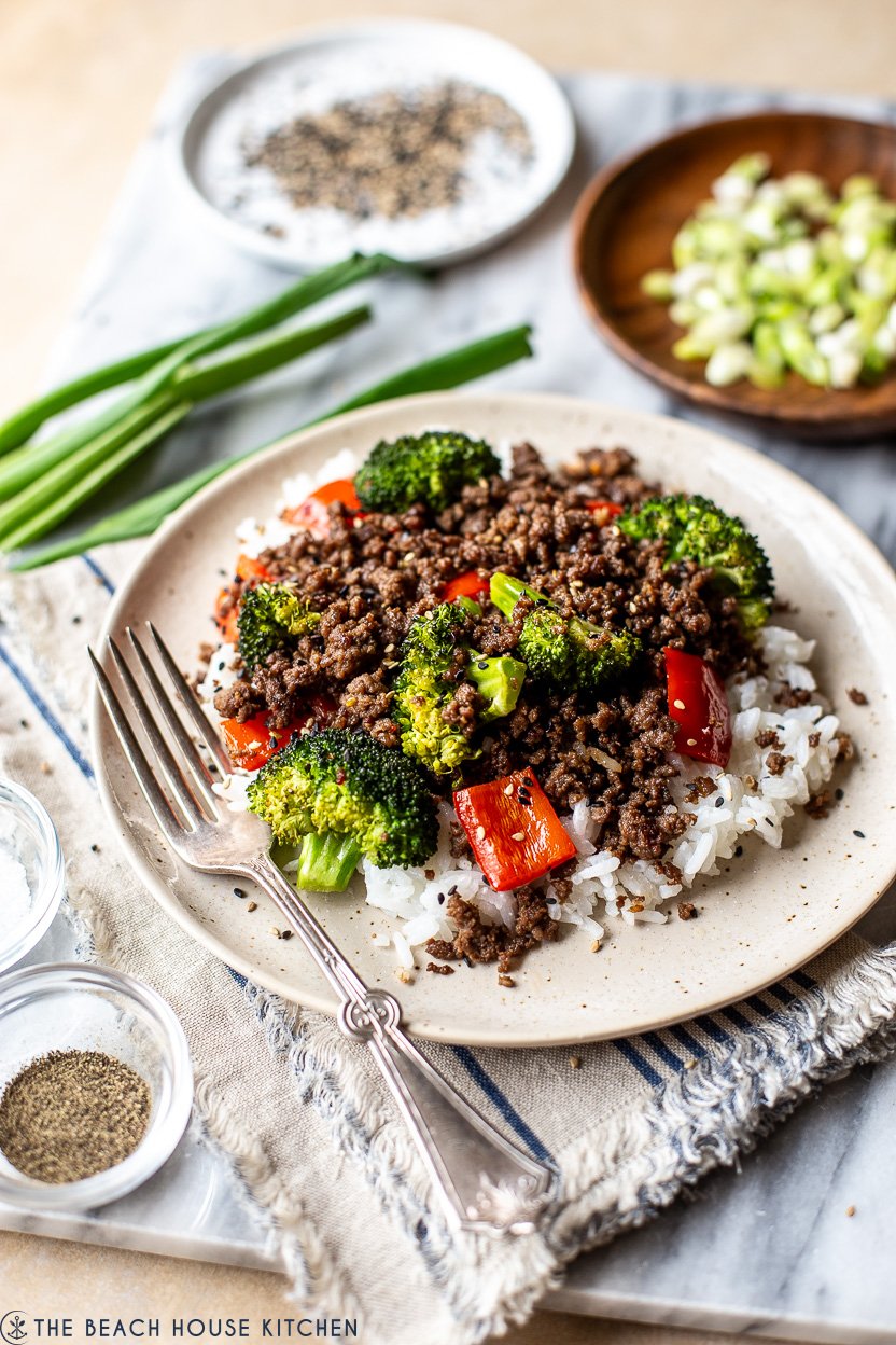 Up close photo of a plate of beef, broccoli and red peppers over rice