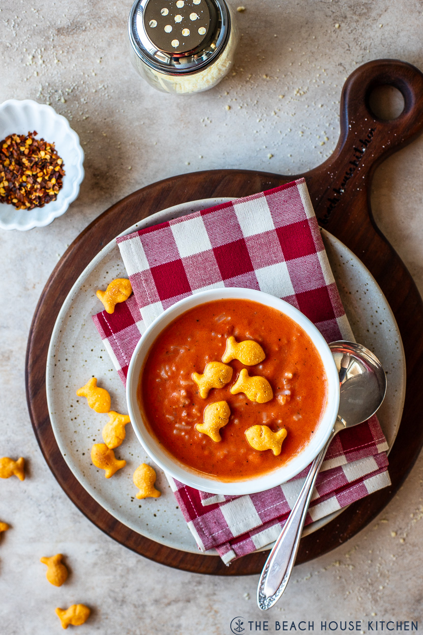 Overhead photo of a bowl of creamy tomato rice soup topped with cheddar goldfish cracker