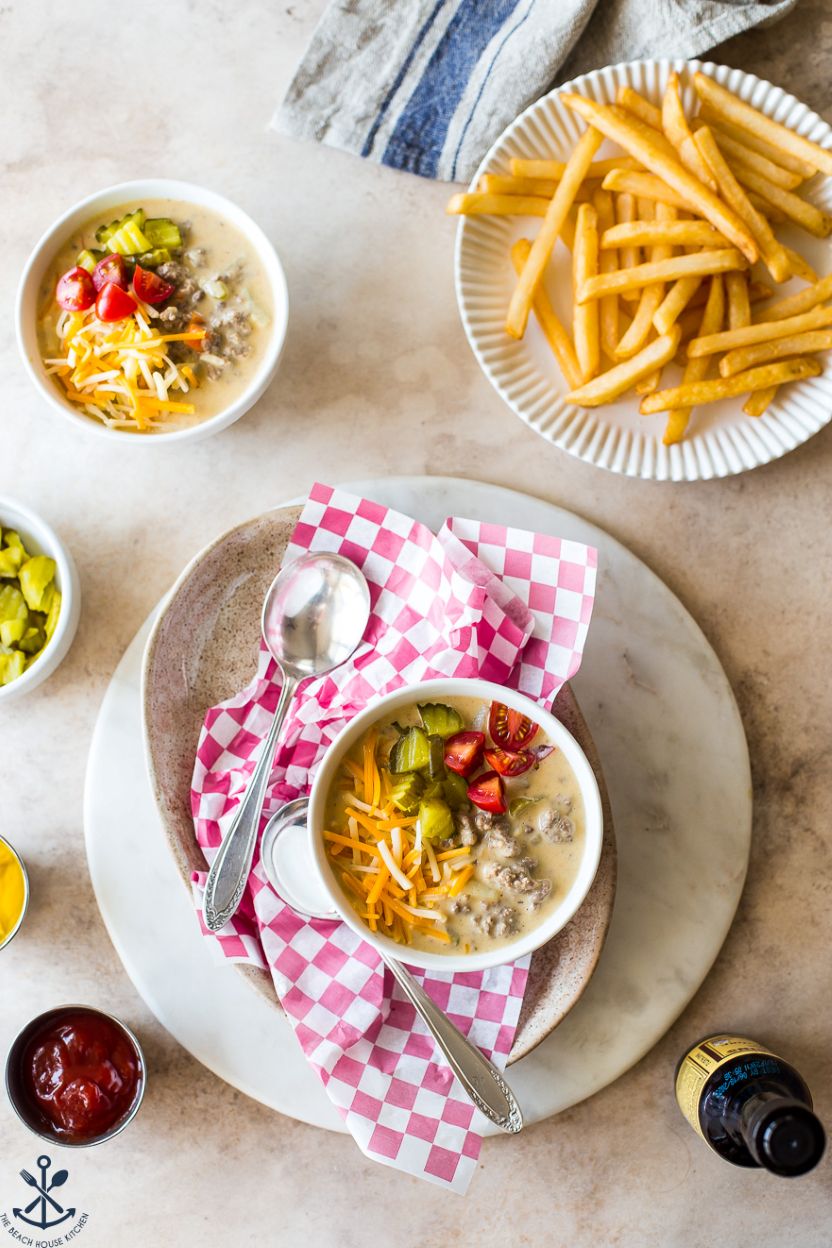Overhead phot of two small bowls of cheeseburger soup with a plate of French fries