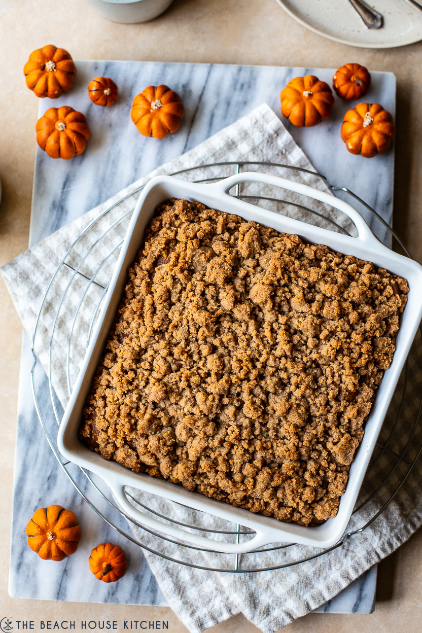 Overhead photo of a pumpkin crumb snack cake in a white square pan